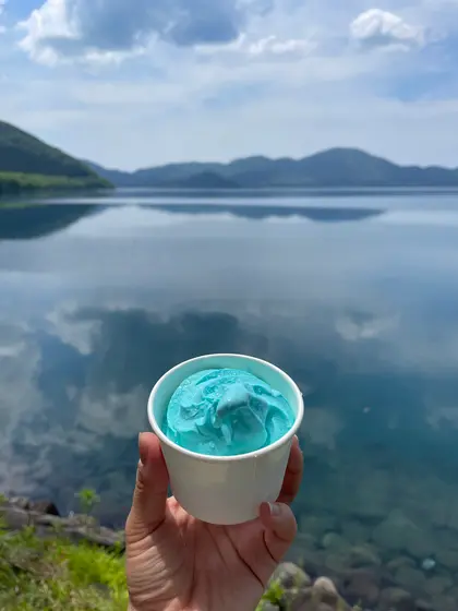 湖と空の色にマッチするラムネ味のアイス