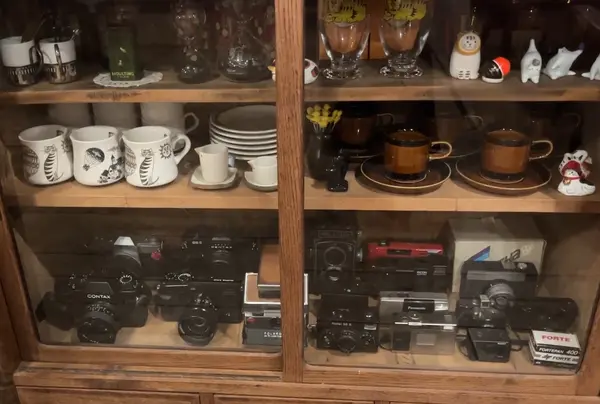 食器類と一緒に古いカメラが飾られている